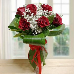 Bouquet "Traguardo Rosso" con sei o sette rose rosse intense e Gypsophila bianche. Fiori freschi avvolti in foglie verdi lucide e nastro rosso per una festa di laurea.