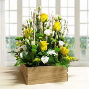 Composizione floreale Sunshine con rose gialle e lisianthus bianchi in cassettina di legno rustica.