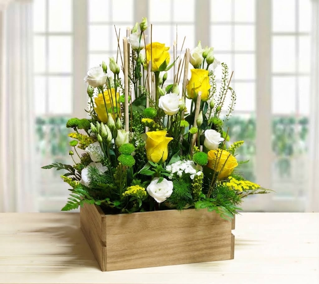 Composizione floreale Sunshine con rose gialle e lisianthus bianchi in cassettina di legno rustica.